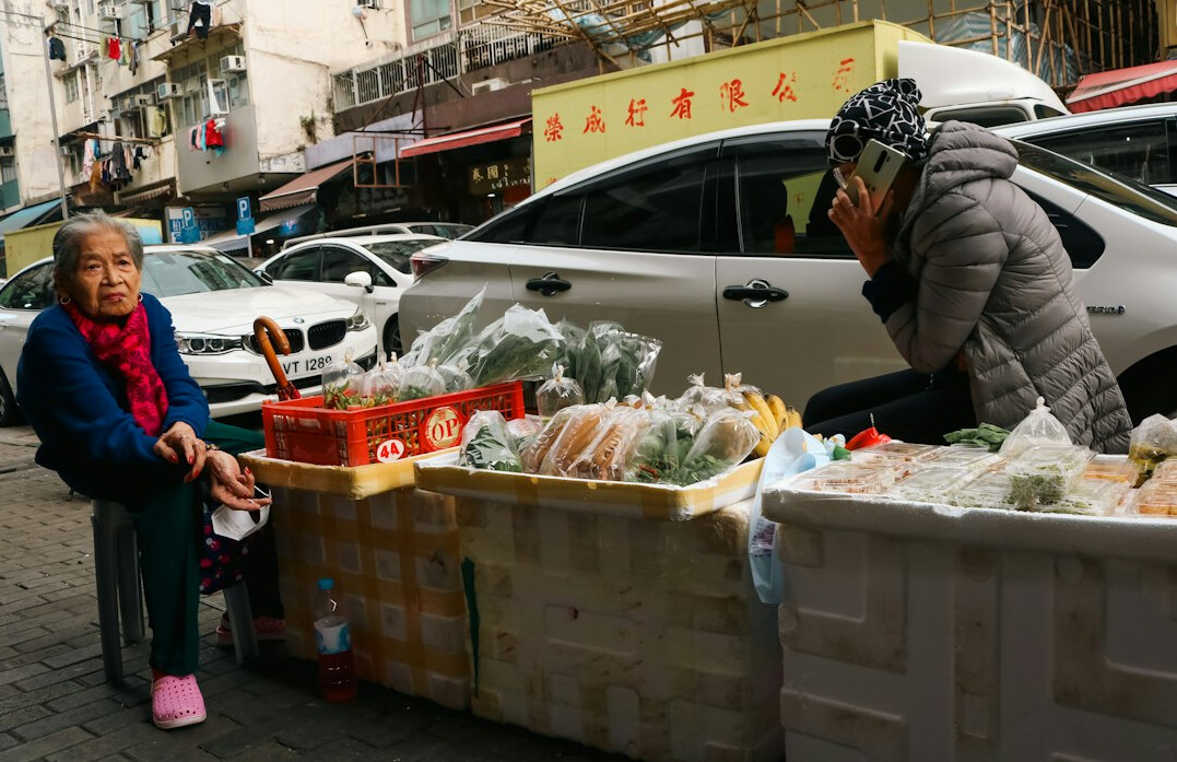 Vendor arranging fresh produce at an outdoor city market