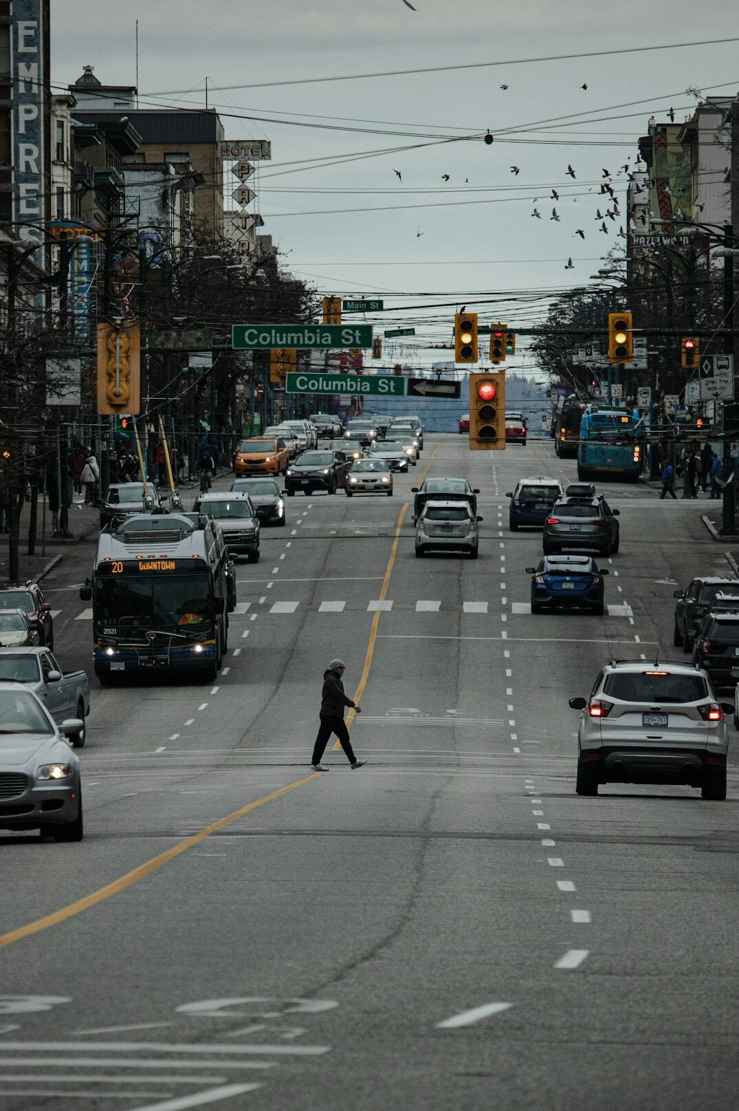 Commuters crossing a busy downtown Canadian street at rush hour